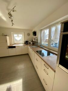a kitchen with white cabinets and a counter top at Ferienwohnung Kobler in Görisried