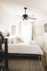 - une chambre avec un lit et un ventilateur de plafond dans l'établissement Nordins Hillside Haven, à Dardanelle