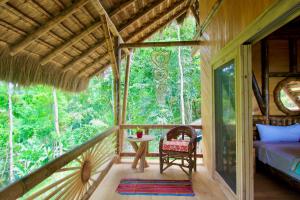 a bedroom in a tree house with a bed and a table at Hermosa vista al Mar y la Montaña I Cabañas Cochapunko in Ayampe