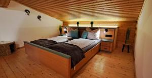 a large bed in a room with a wooden ceiling at Apartment Wegmo in Bischofshofen