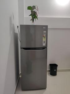 einen kleinen Kühlschrank mit einer Pflanze darüber in der Unterkunft Spacious 2BHK Near Airport in Kochi