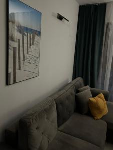 - un canapé brun dans le salon avec une photo sur le mur dans l'établissement Przy Złotych Piaskach, à Sława