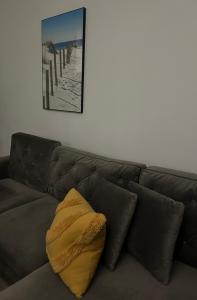 uma almofada amarela sentada em cima de um sofá castanho em Przy Złotych Piaskach em Sława