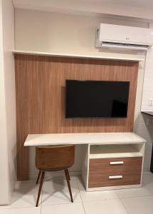 a desk with a television on a wall at Flat em Boa Viagem in Recife