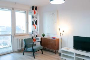 a living room with a chair and a television at Wawaview! Studio with an amazing view! Powiśle. in Warsaw