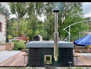 Una parrilla al aire libre con ahumador en un patio. en Moon River, en Saint-Junien