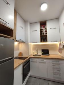 a kitchen with white cabinets and a laptop on the counter at MoonZE apartman, free parking in Novi Grad