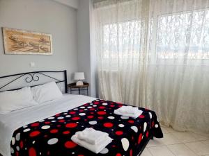 a bedroom with a bed with a polka dot blanket at inspire tripoli in Tripolis