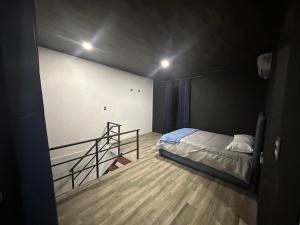 a bedroom with a bed and a staircase in it at Cat’onas apatment in Nicoya