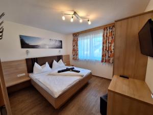 a bedroom with a bed and a flat screen tv at Die Schladmingerin in Schladming