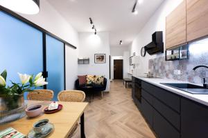 a kitchen and living room with a table and a couch at Native Apartments Pułaskiego 6 in Kraków