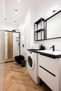 a white bathroom with a washing machine and a sink at Native Apartments Pułaskiego 6 in Kraków