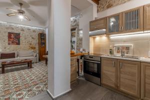a kitchen with wooden cabinets and a living room at Malama's maisonette at the historic center in Heraklio