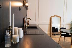 a kitchen with a counter with a sink and a mirror at Suite Amalfi in Lyon