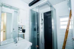 uma casa de banho com uma cabina de duche em vidro e um lavatório. em Au cœur du papillon piscine privée em Goyave