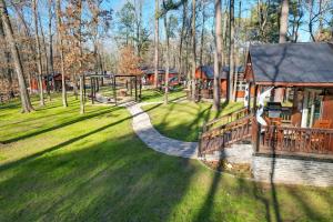 um parque com um parque infantil e uma casa em Hook, Line, and Sinker Retreat Fireplace, Grill! em Broken Bow