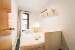 1 dormitorio con 1 cama con sábanas blancas y ventana en Unik Vacation Civaderia, en Tarragona