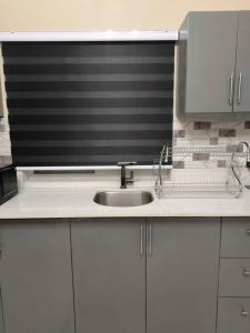 a kitchen counter with a sink and a microwave at KC suites in Government Pen