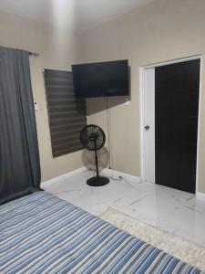 a bedroom with a bed and a flat screen tv at KC suites in Government Pen
