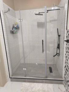 a shower with a glass door in a bathroom at KC suites in Government Pen