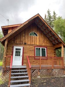 費爾班克斯的住宿－Cozy Alaskan Log Home - Aurora overhead，小屋设有门廊和白色门