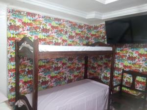 Litera en habitación con papel pintado floral en Casa Da Lucia, en Salvador