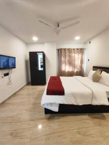 a bedroom with a large bed and a flat screen tv at Lily Homes in Guwahati