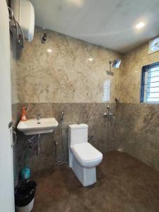 a bathroom with a toilet and a sink at Lily Homes in Guwahati
