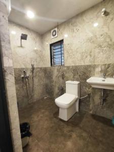 a bathroom with a toilet and a sink at Lily Homes in Guwahati