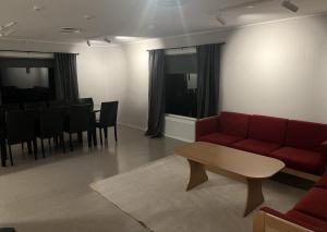 a living room with a red couch and a table at Helt hus: Sneveien 75 in Bodø