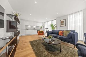 a living room with a blue couch and a table at Atlas House Three in Harrogate