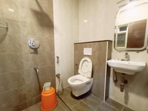 a bathroom with a toilet and a sink at MRV Inn Triplicane in Chennai