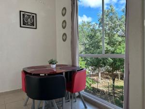 ein Esszimmer mit einem Tisch, Stühlen und einem Fenster in der Unterkunft Departamento 2 habitaciones alberca Luna by Eita in Cancún