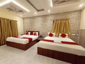 a hotel room with two beds and curtains at MRV Inn Triplicane in Chennai