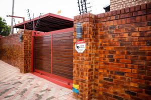 a brick wall with a door with a sign on it at HANA GUESTHOUSE in Pretoria