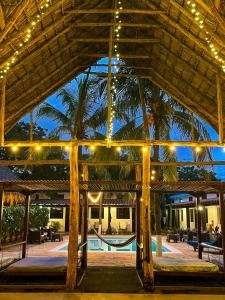 a pavilion with a pool and palm trees and lights at Room to Roam in Rivas