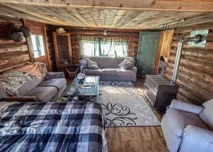a living room with a bed and a couch at Mountain Made- Main Cabin in Collbran