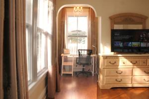 a room with a dresser and a desk and a window at MayLi Place Luxury King Suite Downtown St Augustine in Saint Augustine