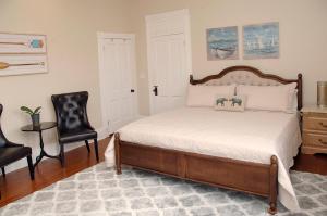 a bedroom with a bed and two chairs at MayLi Place Luxury King Suite Downtown St Augustine in Saint Augustine