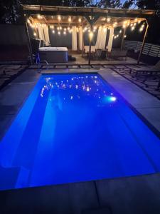 una piscina iluminada de azul por la noche en Manchaca Meadows - 4 Bedroom Villa, en Manchaca