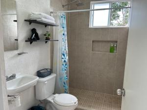 a bathroom with a shower and a toilet and a sink at Departamento 2 habitaciones alberca Luna by Eita in Cancún