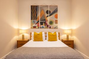 a bedroom with a bed with two yellow pillows at Charming Euston in London