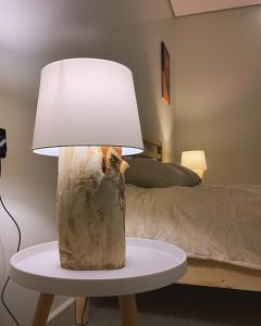 une lampe sur une table à côté d'un lit dans l'établissement unique chalet, à Unayzah