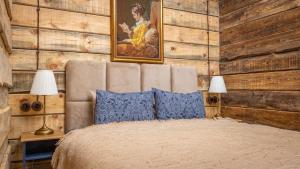 a bedroom with wooden walls and a bed with blue pillows at Chalet Mountain Deer in Kolašin