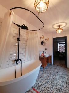 a bath tub in a bathroom with a chandelier at Kosowisko in Miłki