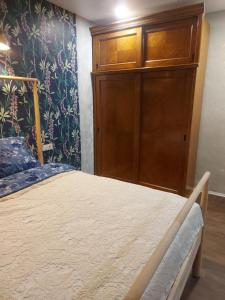 - une chambre avec un lit et une armoire en bois dans l'établissement Apartamentai poilsiui, à Telšiai