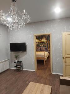 ein Wohnzimmer mit einem Bett und einem Kronleuchter in der Unterkunft Apartamentai poilsiui in Telšiai