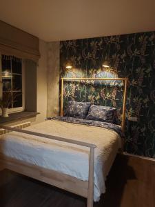 ein Schlafzimmer mit einem Bett mit Blumenwand in der Unterkunft Apartamentai poilsiui in Telšiai