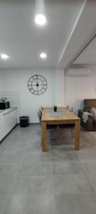 a living room with a wooden table and a clock on the wall at Apartamento Sofia in Santa Pola