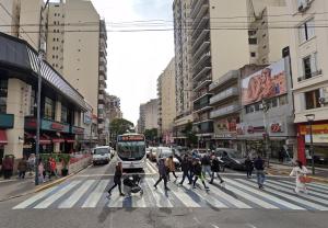 un grupo de personas cruzando una concurrida calle de la ciudad con un autobús en M Pugliese Amplio, cómodo y luminoso a metros del subte en Buenos Aires
